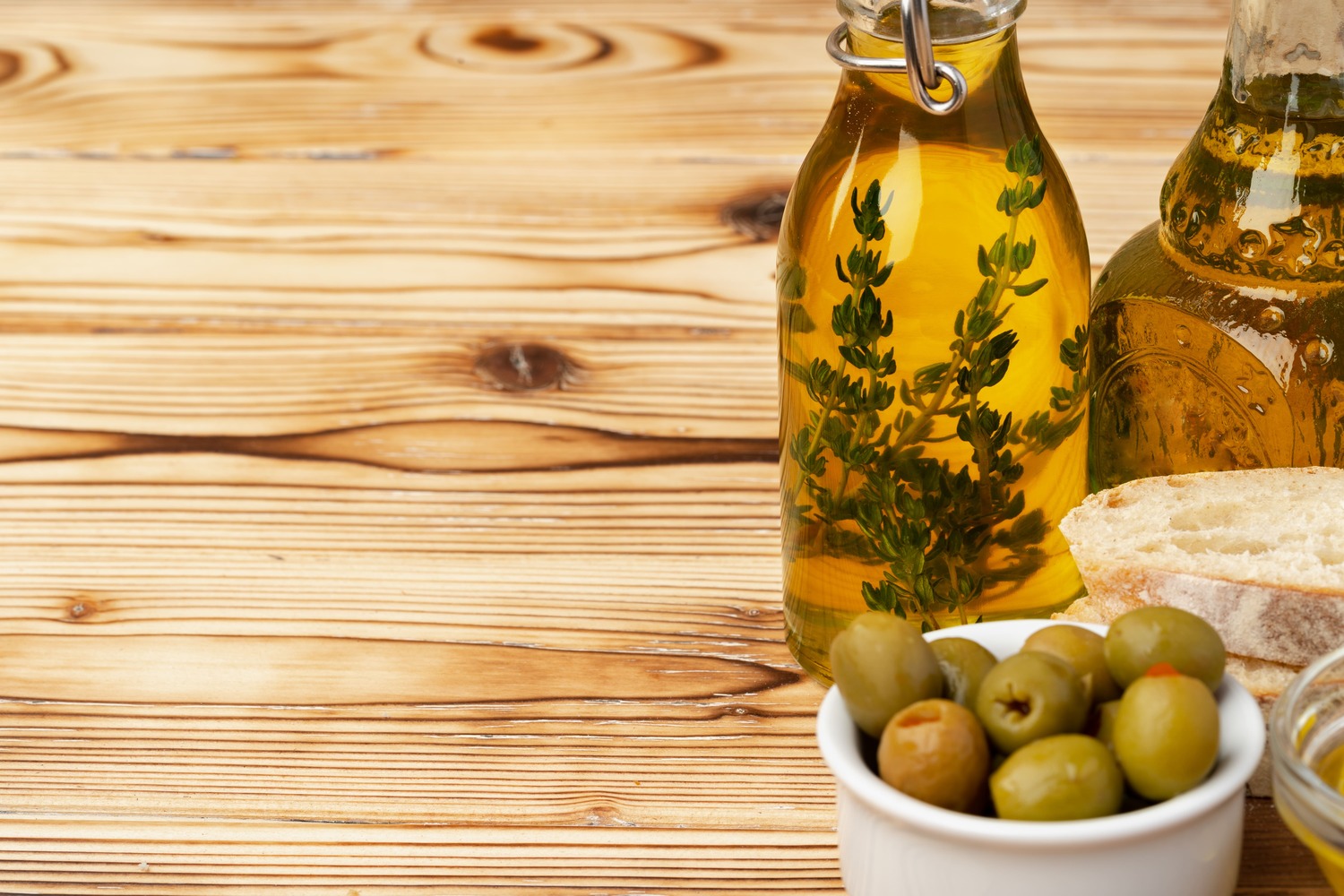 olives-and-bottle-of-olive-oil-on-wooden-backgroun-2022-02-24-15-24-14-utc-1.jpg